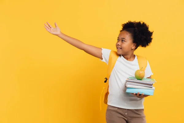 Африканська Американська Школярка Тримає Зошити Книжки Показує Щось Жовтому Фоні — стокове фото