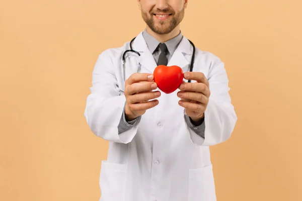 Der Männliche Kardiologe Mit Herz Auf Beigem Hintergrund — Stockfoto