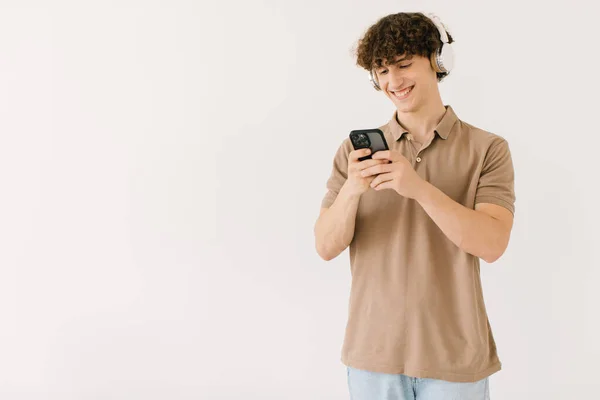 Attrayant Jeune Étudiant Masculin Dans Les Écouteurs Modernes Utilisant Téléphone — Photo