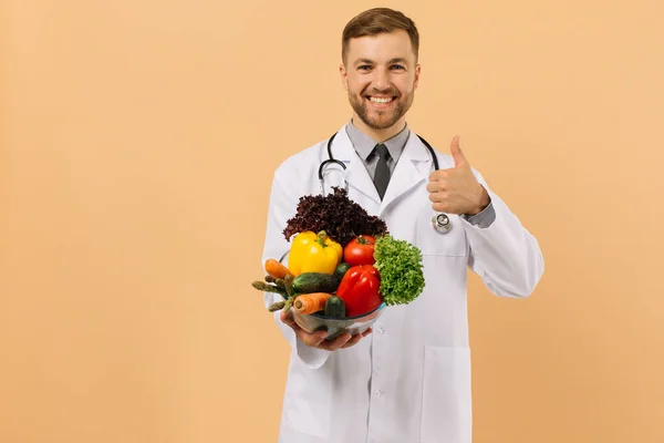 Nutricionista Médico Macho Feliz Com Estetoscópio Mostra Vegetais Frescos Fundo — Fotografia de Stock