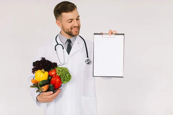 Médico Nutricionista Masculino Con Estetoscopio Sosteniendo Verduras Frescas Carpeta Con —  Fotos de Stock
