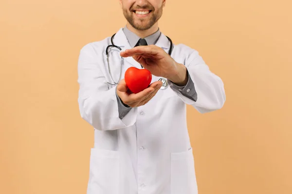 Lekarz Kardiolog Trzymający Serce Beżowym Tle — Zdjęcie stockowe