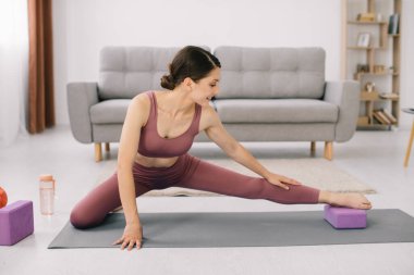 Çekici ve sağlıklı genç kadının evde istirahat ederken egzersizleri yapması