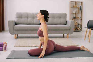 Çekici ve sağlıklı genç kadının evde istirahat ederken egzersizleri yapması