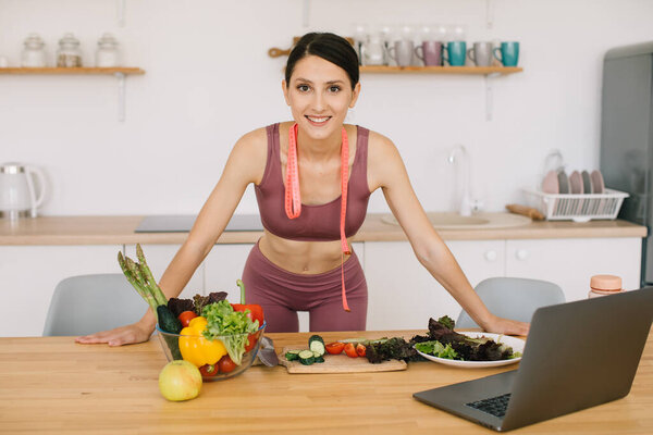 Портрет спортивной женщины-блогера ведущей видеоконференции по здоровому питанию на ноутбуке на кухне