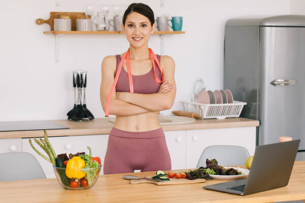 Портрет счастливой спортивной женщины-блоггера за столом со свежими овощами, концепция здорового питания