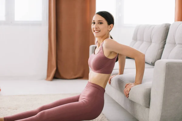 Mujer Joven Atractiva Saludable Haciendo Flexiones Sofá Mientras Descansa Casa — Foto de Stock