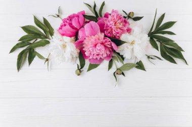 Beyaz ahşap arka planda pembe ve beyaz şakayıklar, kopyalama alanı, düzlük, tebrik kartı.