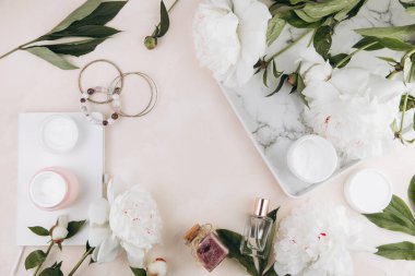 Kadın eşyalarıyla ve şakayık çiçekleriyle güzellik kompozisyonu, kozmetik, parfüm, mücevher.