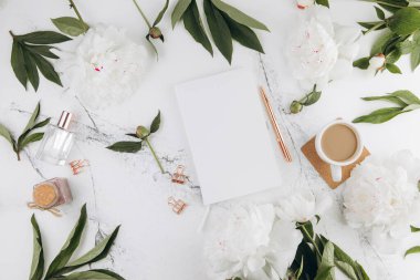 Kadın mermer masası, günlük modeli beyaz şakayıklar ve etrafta kahve, düz yatış.