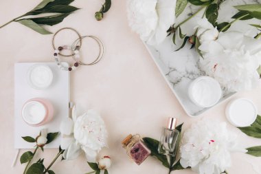 Kadın eşyalarıyla ve şakayık çiçekleriyle güzellik kompozisyonu, kozmetik, parfüm, mücevher.