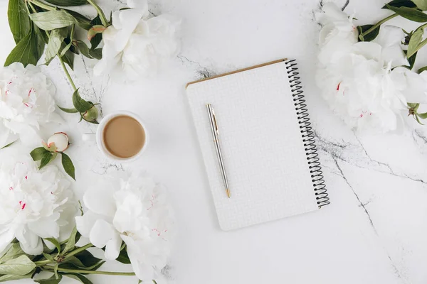 stock image Beautiful white peony flowers with empty notebook on white marble stone background, copy space for your text or design, top view, flat lay