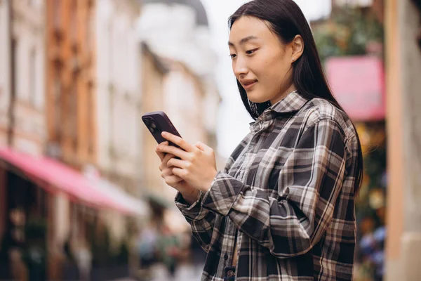旧市街の通りに美しい韓国人女性の肖像画 携帯電話で話すカジュアルな服でアジアの女性 近代的な技術とライフスタイル — ストック写真