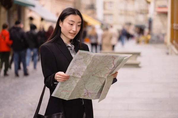 古いヨーロッパの都市の通りに地図を保持している美しい韓国の女性の肖像画 ヨーロッパを旅行するアジアの女性観光客やビジネス女性 — ストック写真