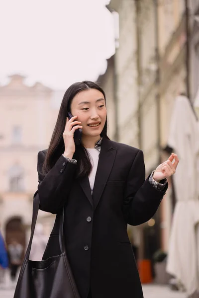Portrait of a beautiful Korean woman. Asian woman in casual clothes talking on the phone, modern technology and lifestyle.