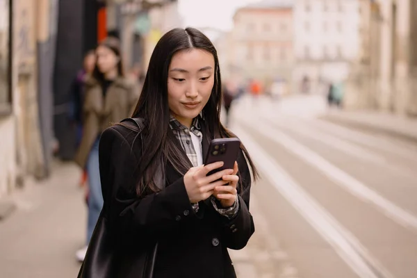 若い忙しい成功した美しいアジアのビジネス女性 スマートフォンスタンドを使用して携帯電話を保持する韓国のビジネス女性や外の古い街の通りを歩く — ストック写真