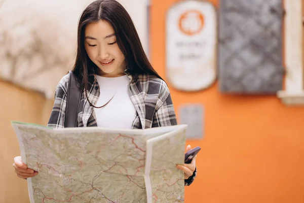 古い街の通りに地図を持っている美しい幸せなブルネットの韓国人女性の肖像画 ヨーロッパを旅するアジアの女性観光客の女性 — ストック写真