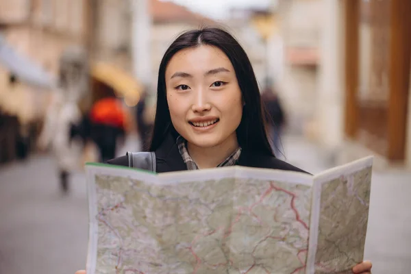 古いヨーロッパの都市の通りに地図を保持している美しい韓国の女性の肖像画 ヨーロッパを旅行するアジアの女性観光客やビジネス女性 — ストック写真