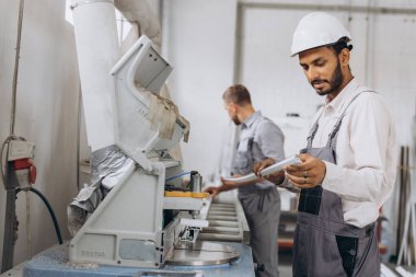 Uluslararası bir ekip, iki işçi PVC pencere ve kapı fabrikasında çalışıyor.