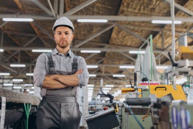 Fabrika erkek sakallı işçi bir CNC değirmen makinesini kopyalama alanı ile programlıyor..