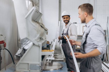 Uluslararası bir ekip, iki işçi PVC pencere ve kapı fabrikasında çalışıyor.