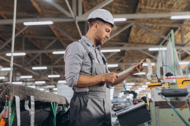Fabrika erkek sakallı işçi bir CNC değirmen makinesini kopyalama alanı ile programlıyor..