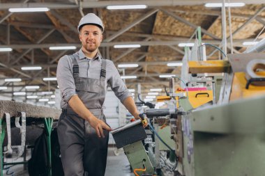 Fabrika erkek sakallı işçi bir CNC değirmen makinesini kopyalama alanı ile programlıyor..