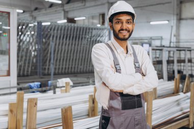 Makine operatörü. Fabrikada sanayi işçisi. Beyaz şapkalı genç teknisyen..