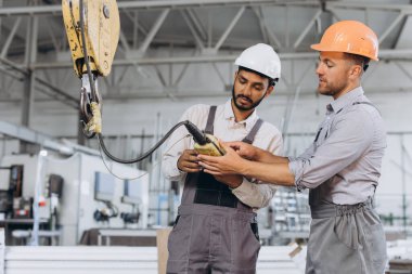Uluslararası bir ekip, fabrika işçileri asansörü çalıştırıyor..