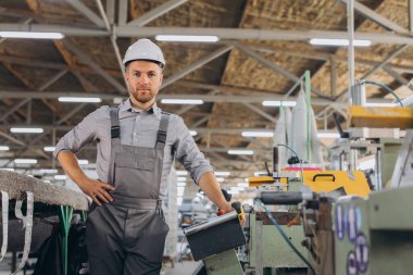 Fabrika erkek sakallı işçi bir CNC değirmen makinesini kopyalama alanı ile programlıyor..