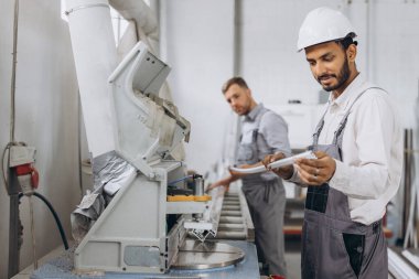 Uluslararası bir ekip, iki işçi PVC pencere ve kapı fabrikasında çalışıyor.