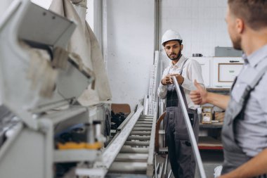 Uluslararası bir ekip, iki işçi PVC pencere ve kapı fabrikasında çalışıyor.