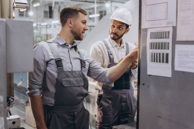 Deneyimli mühendisler üretim fabrikasında modern endüstriyel üretim makinesine hizmet veriyorlar.