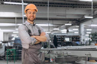Makine operatörü. Fabrikada sanayi işçisi. Turuncu şapkalı genç teknisyen..