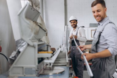 Uluslararası bir ekip, iki işçi PVC pencere ve kapı fabrikasında çalışıyor.