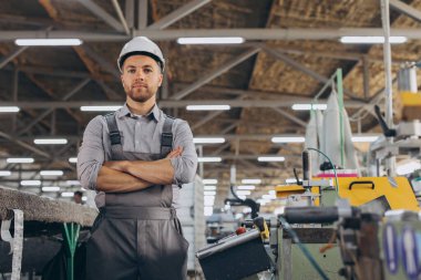 Fabrika erkek sakallı işçi bir CNC değirmen makinesini kopyalama alanı ile programlıyor..