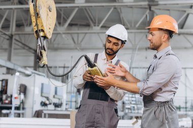 Uluslararası bir ekip, fabrika işçileri asansörü çalıştırıyor..