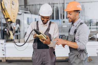 Uluslararası bir ekip, fabrika işçileri asansörü çalıştırıyor..