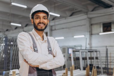 Makine operatörü. Fabrikada sanayi işçisi. Beyaz şapkalı genç teknisyen..