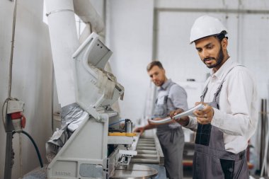 Uluslararası bir ekip, iki işçi PVC pencere ve kapı fabrikasında çalışıyor.