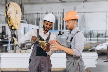 Uluslararası bir ekip, fabrika işçileri asansörü çalıştırıyor..