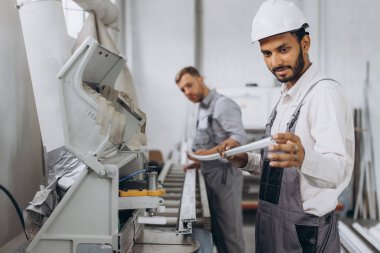 Uluslararası bir ekip, iki işçi PVC pencere ve kapı fabrikasında çalışıyor.