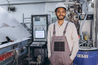 Makine operatörü. Fabrikada sanayi işçisi. Beyaz şapkalı genç teknisyen..