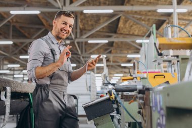 Fabrika erkek sakallı işçi bir CNC değirmen makinesini kopyalama alanı ile programlıyor..