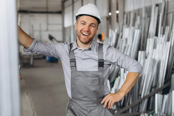 穿着灰色制服 头戴白色硬礼帽的快乐工人在工厂生产背景下的画像 — 图库照片