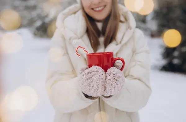 在冬天的公园里 穿着针织手套 拿着加糖的热咖啡的可爱的快乐女人 — 图库照片