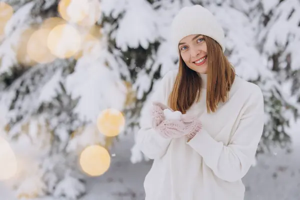 冬の雪の日に雪の心を保持する編まれたミトンで幸せな女性 — ストック写真