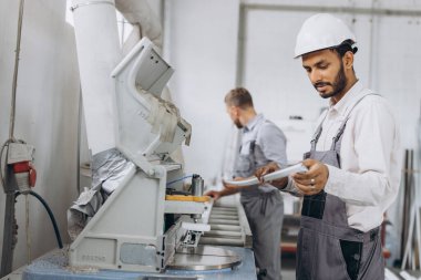 Uluslararası bir ekip, iki işçi PVC pencere ve kapı fabrikasında çalışıyor.