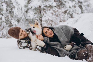 Mutlu genç çift ve akita köpeği kış günü ormanda