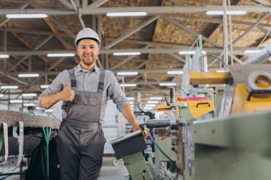 Fabrika erkek sakallı işçi bir CNC değirmen makinesini kopyalama alanı ile programlıyor..